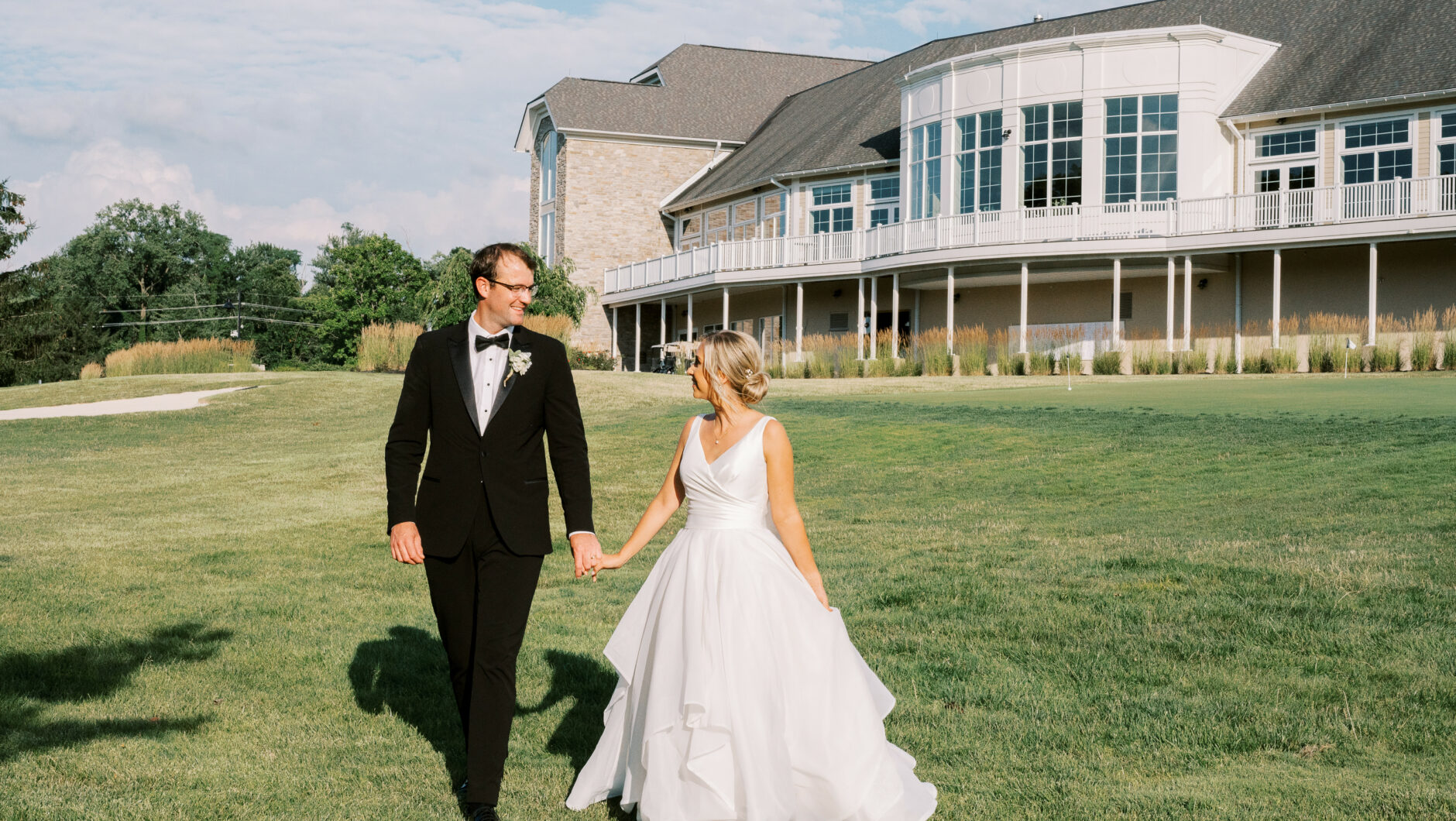 bride and groom holding hands and walking next to Cooper Creek venue
