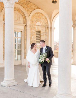 Bride and Groom in front of stone carved archways at Ault park at sunset