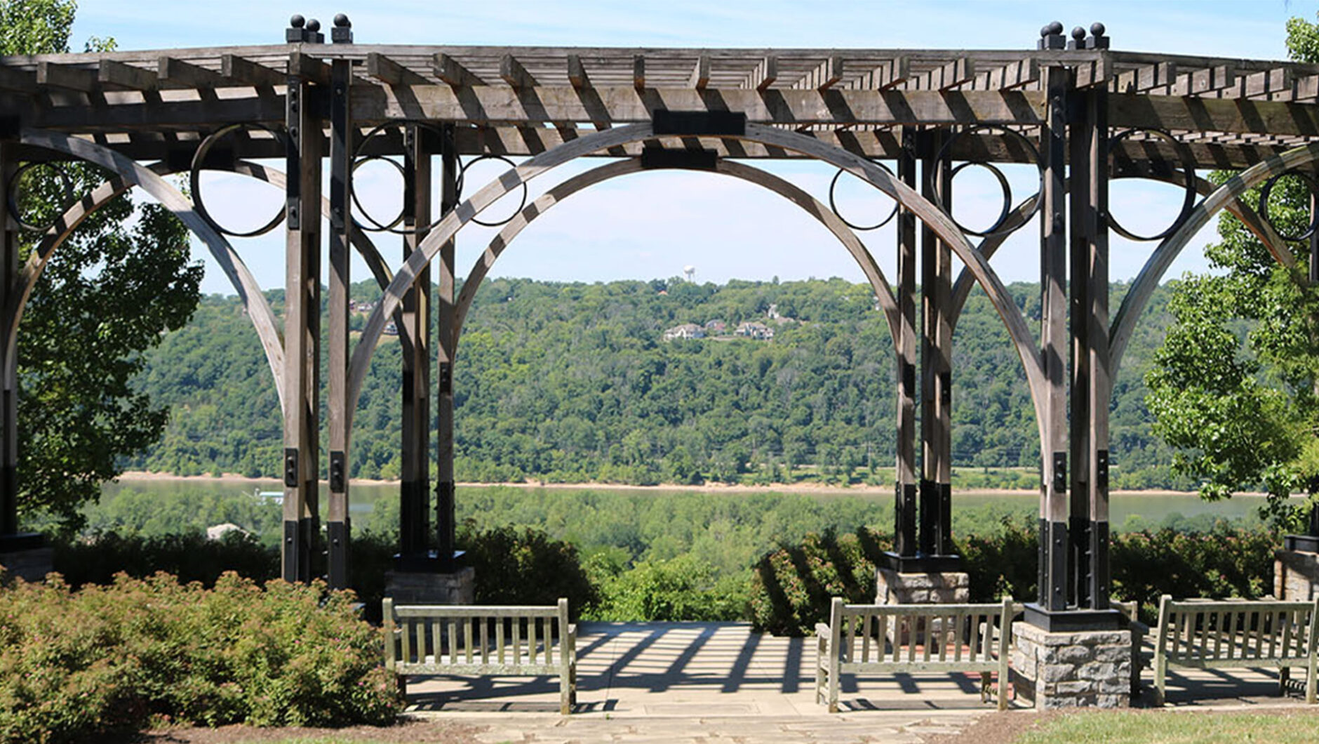 A wooden pergola in front of an overlook at Alms Park