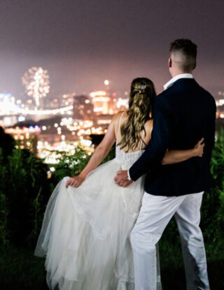 Bride and groom looking out at fireworks over Cincinnati, Ohio